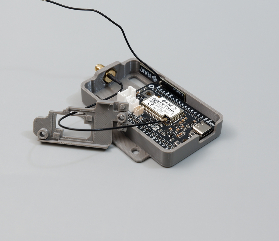 Routing the LoRa RP-SMA pigtail cable through the side slit and snapping the MHF4 connector to the LORA port